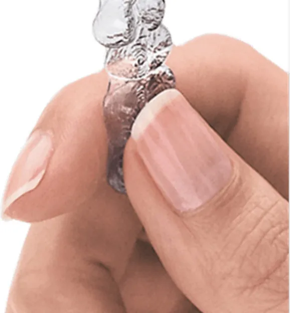 A clear Invisalign aligner held between two
          fingers