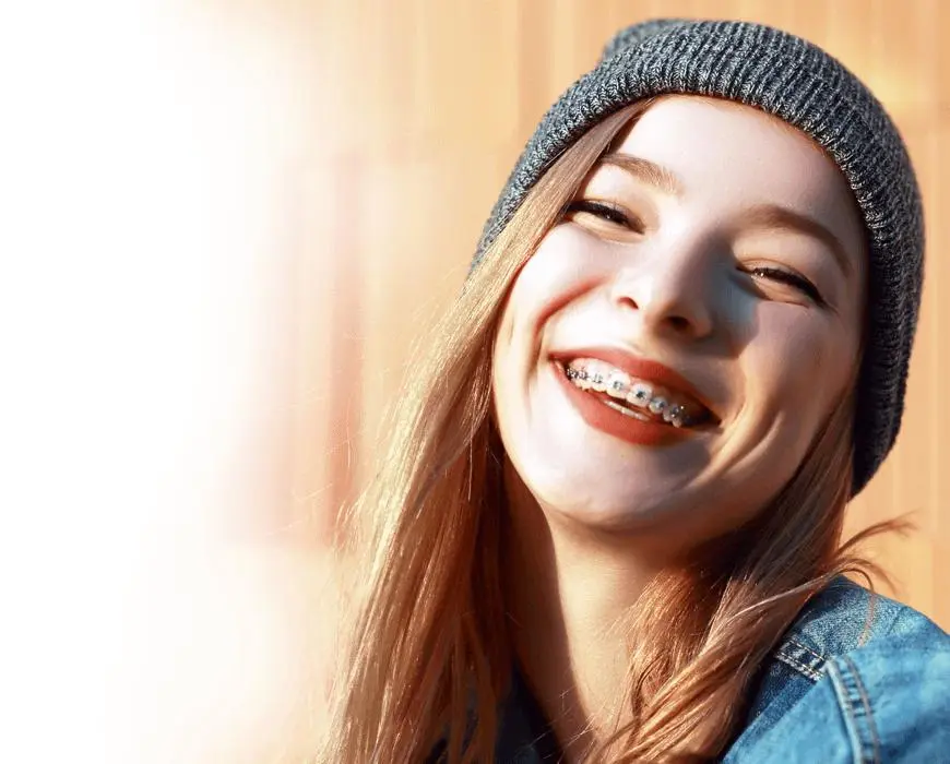 A smiling teenager wearing fixed metal braces